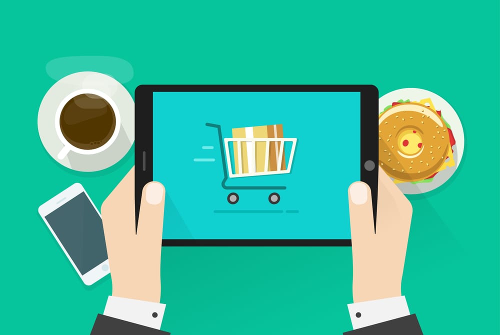 A person holds a tablet displaying an online shopping cart icon filled with boxes, symbolizing holiday success. Nearby, a cup of coffee, a plate with a burger, and a smartphone rest on the vibrant green background.